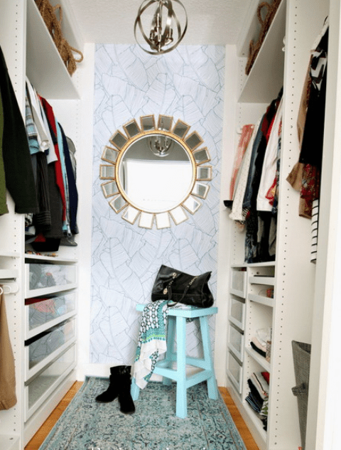 A metal sphere chandelier, a sun-inspired mirror and a blue stool finish up the look and make the closet glam-styled