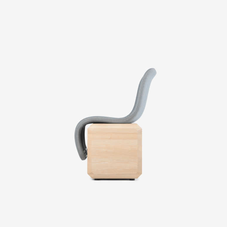 The design includes a sharp contrast between the organic profile of the seat and the geometric sturdy base