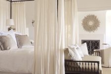 04 black frame canopy bed with airy white curtains for a dreamy feel