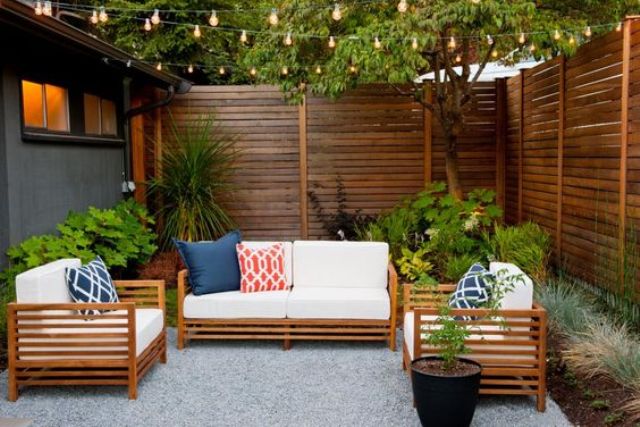 chic stained wooden privacy fence and furniture that echoes that shade of stain