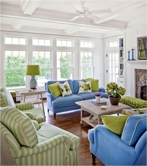 shades of green and blue in this living room are complemented with white and beige for a cozy feel