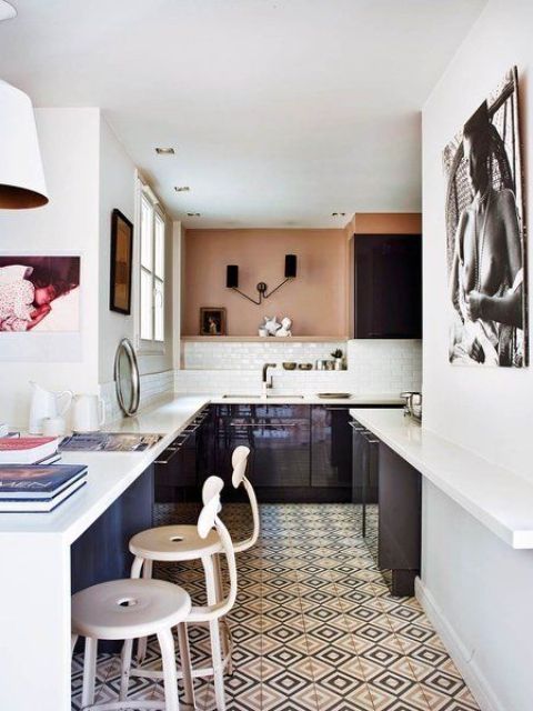 The kitchen is modern and sleek, in very dark purple and with contrasting white countertops, and an African woman portrait reminds of the boho feel