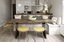 05 modern white sleek kitchen with grey tiles and a dining space with metal wire chairs grey pillows to echo