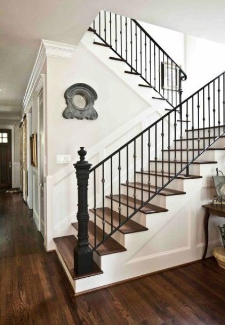 Sharp looking staircase with metal posts and wrought iron railing