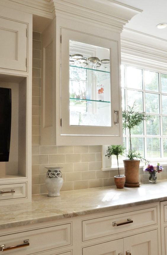 traditional cabinetry with beige subway tiles and matching quartz counters