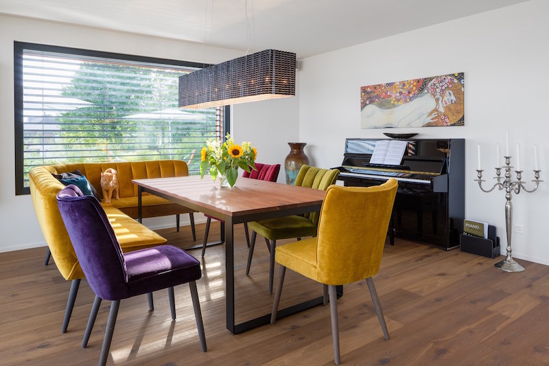 The dining area is colorful and inviting, with upholstered chairs of jewel colors