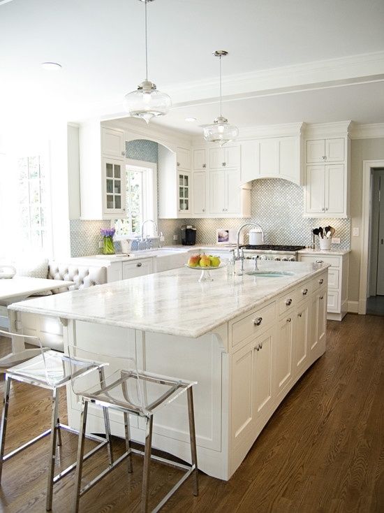 All white kitchen decor with a silver backsplash and white quartz counters for a serene look
