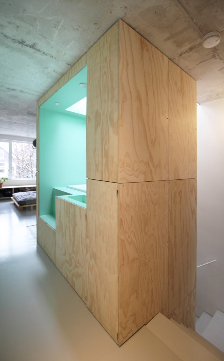 A bathroom combo is located inside a wooden cube