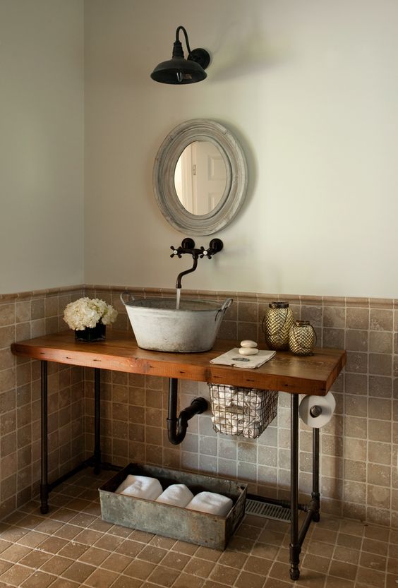 a galvanized bathroom sink on a wooden countertop with black pipe legs