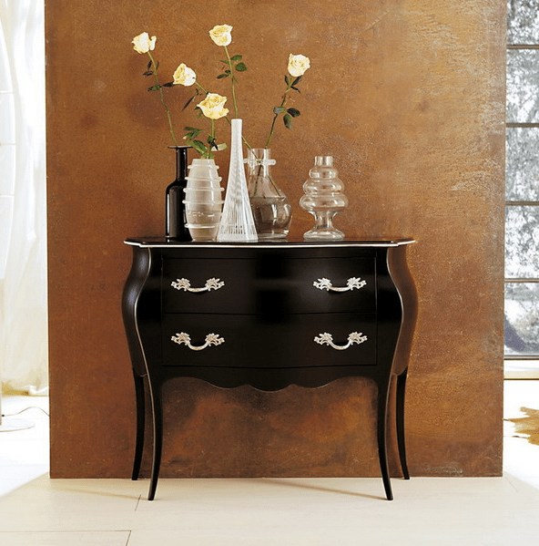 dark wood dresser with shining metal handles and lots of vases on display