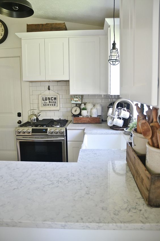 white rustic kitchen with subway tiles and white quartz counters