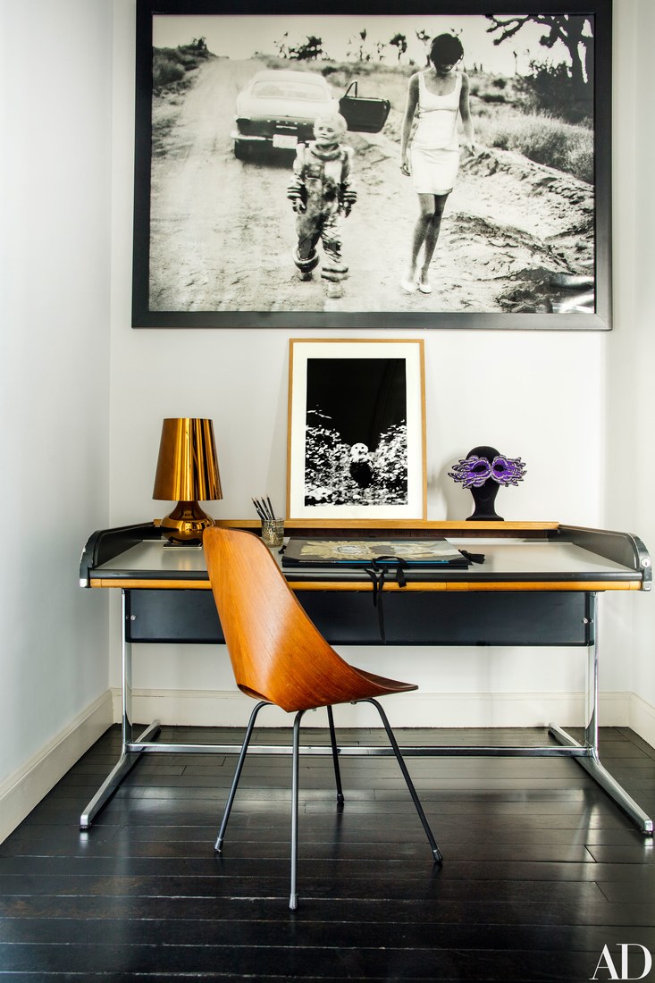 Home office nook with a black desk and a bent wood chair, there are bold orange-ocher details that make it cozier