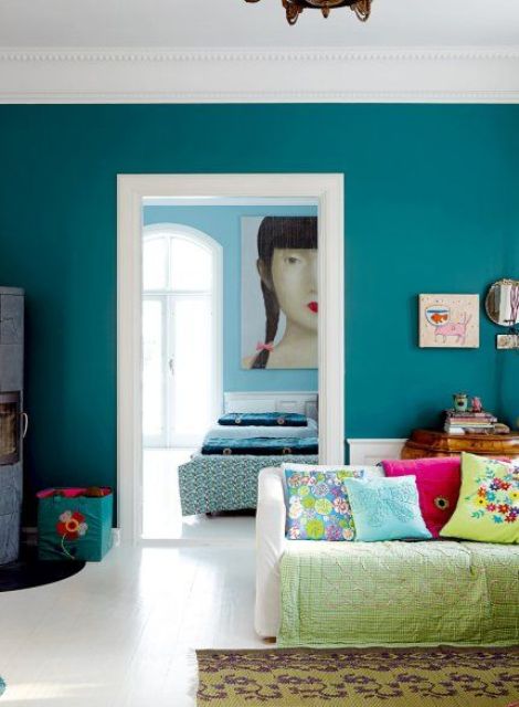 a teal statement wall and lime green accessories are a great combo for a vivacious living room