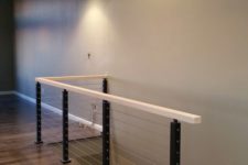 11 black steel posts, white wood and cable railing for a sleek modern look