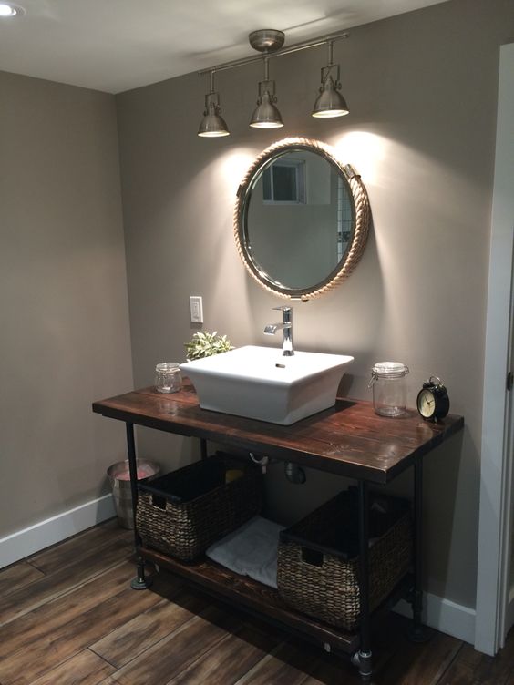 dark stained wooden and metal pipe vanity with baskets instead of drawers