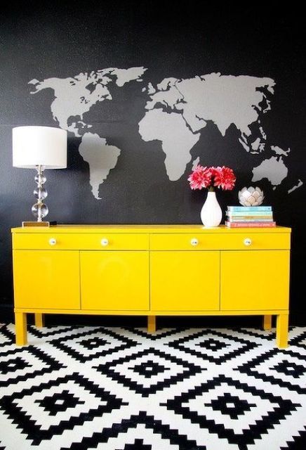 Black and grey world map wall mural looks contrasting with a neon yellow sideboard.