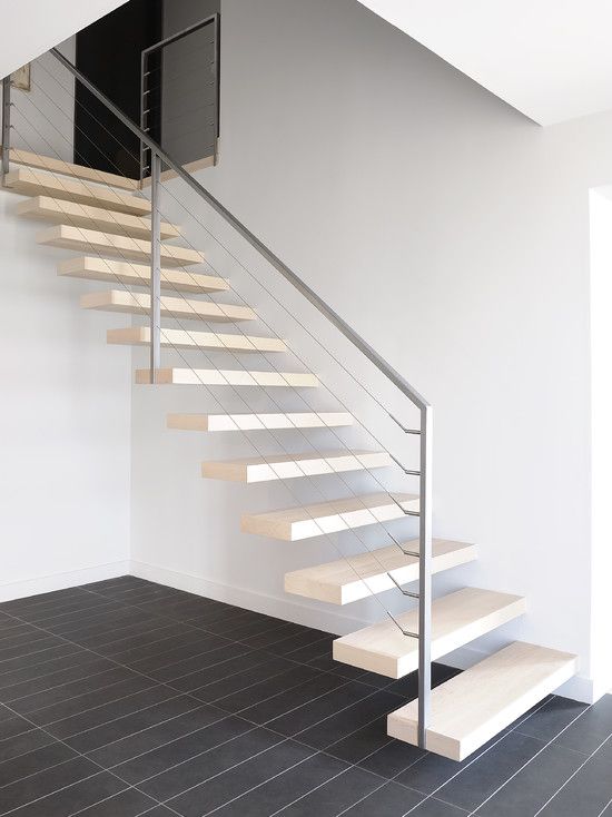 Light colored floating stairs with metal and cable railing