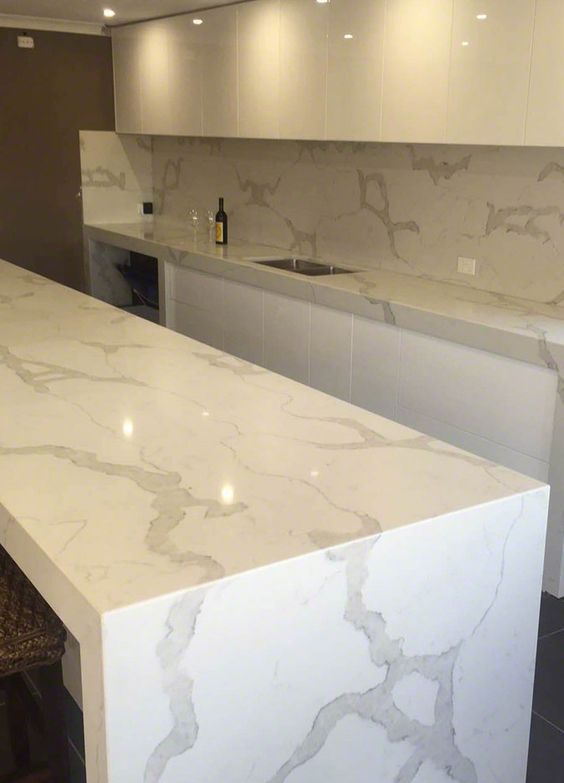 minimalist white kitchen with chic quartz counters looking like marble