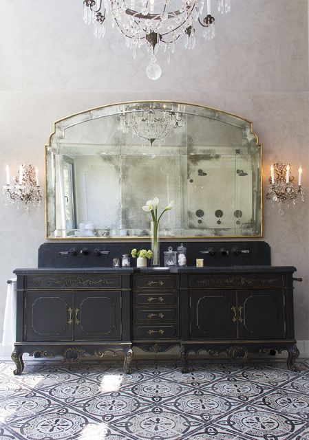 refined black vanity with gold contours and a large mirror