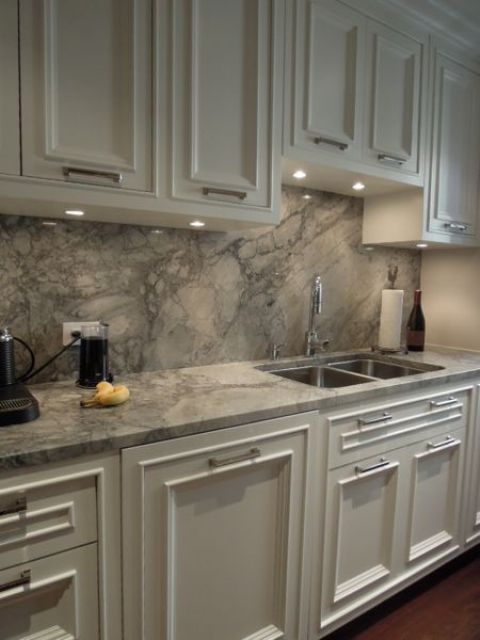 white cabinets and grey quartz counters and a backsplash for a stylish statement