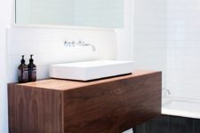 16 a dark wooden floating cabinet with a white sink looks chic and laconic