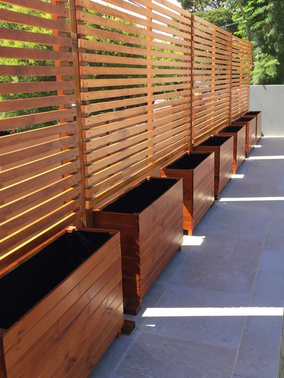 wooden privacy screens with planters to make your backyard cozier