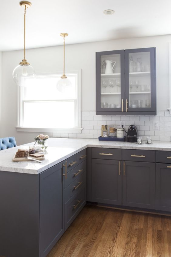 vintage dark grey cabinets with white quartz countertops and brass details