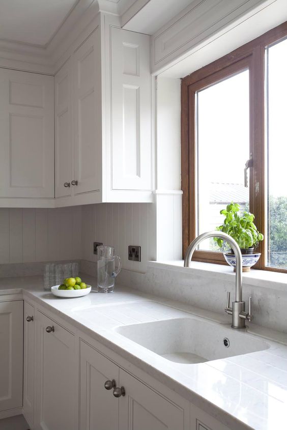 all-white kitchen with tiles and quartz counters