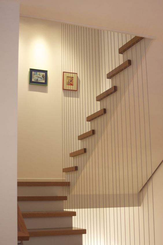 vertical cable railing gives a unique look to this staircase and separates it from the rest of the space
