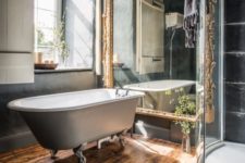 21 dark bathroom decor, a vintage free-standing bathtub and a large mirror in a refined gilded frame