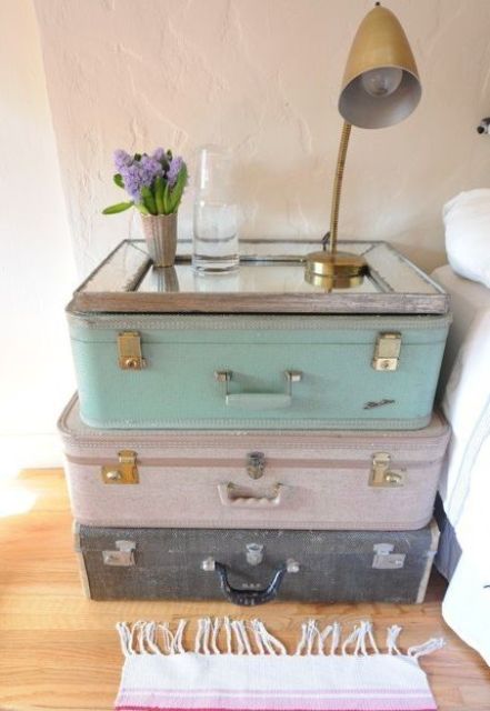 Old suitcases stacked on each other and a mirror on top for a unique nightstand.