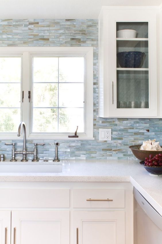 white cabinets, small blue tiles all over and white quartz countertops
