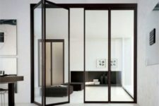 22 folding black frame glass doors separating the kitchen and the living room