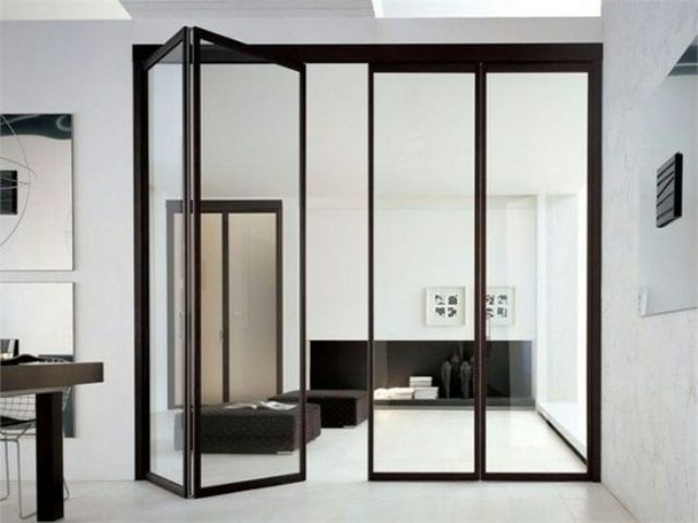 folding black frame glass doors separating the kitchen and the living room