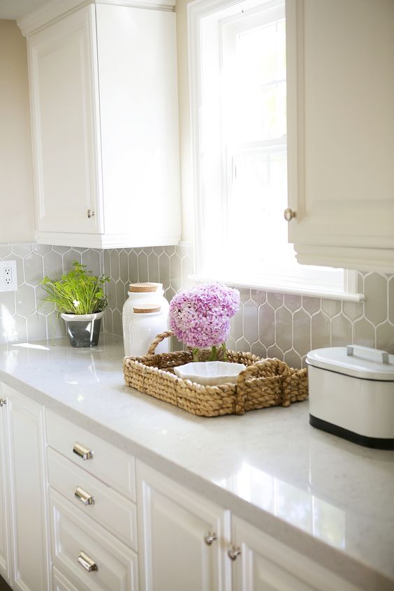 traditional white kitchen with grey hexagon tiles and and off-white quartz counters