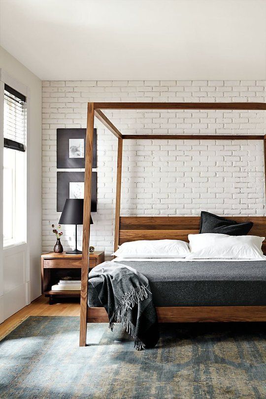 wooden frame bed makes this industrial-inspired bedroom cozier