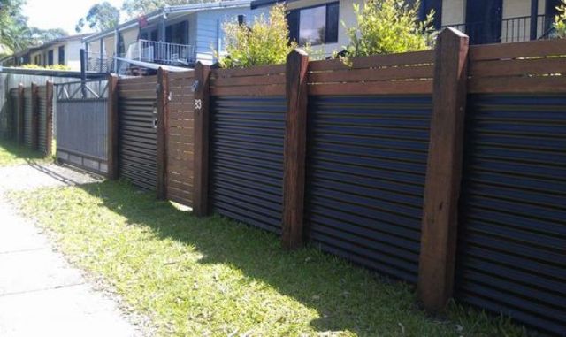 Wood and corrugated metal create a very eye catchy and stylish fence