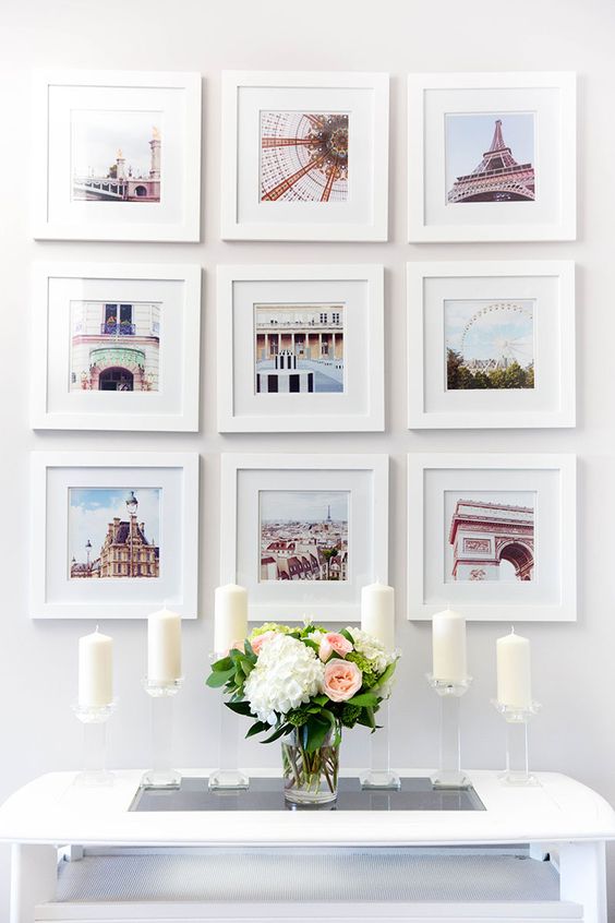 Light-filled and sweet photo gallery wall with pics from trips, all of them in white frames and of the same size.
