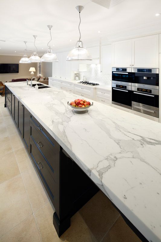 modern white kitchen cabinets and a black kitchen island with chic white quartz countertops