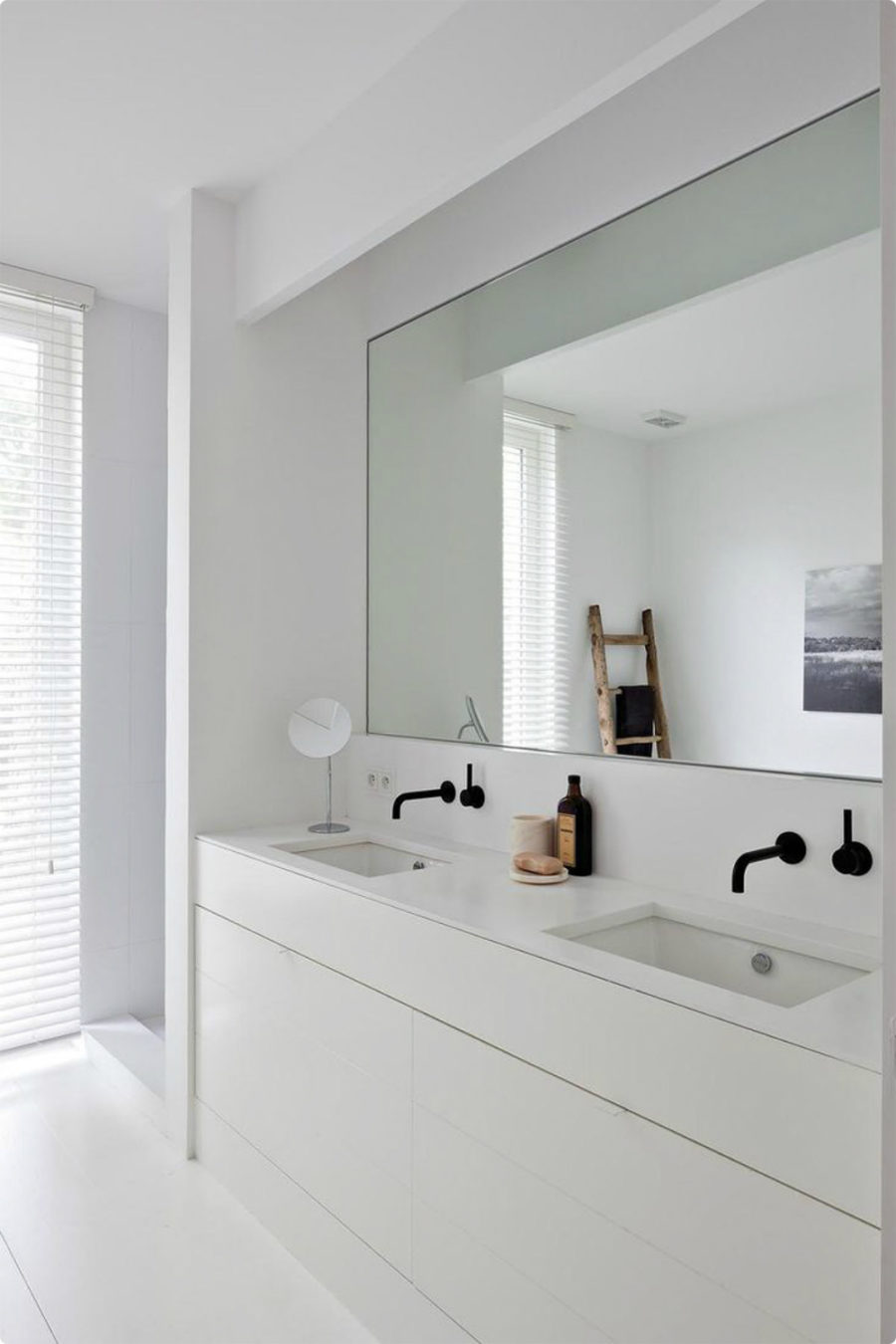Ultra minimalist white bathroom with a mirror niche to accentuate the sink area