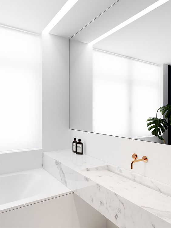 small white marble modern bathroom with a mirror and counter in a niche