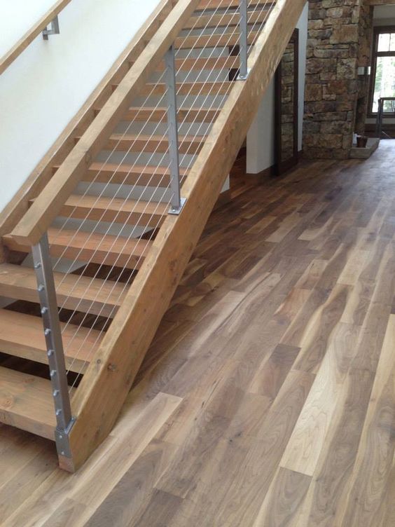 warmcolored wood staircase and wood and cable railing to give it a fresher modern look