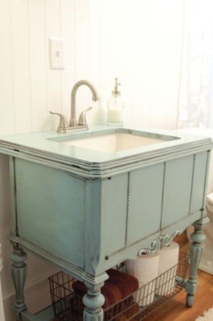 repurposed sewing machine cabinet was painted patina color and used as a vanity