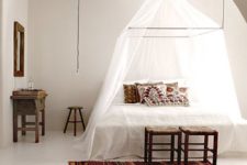 27 a boho chic inspried bedroom with a bed with a canopy frame attached to the ceiling