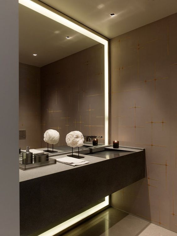 dark glam bathroom with a lit up mirror in a niche