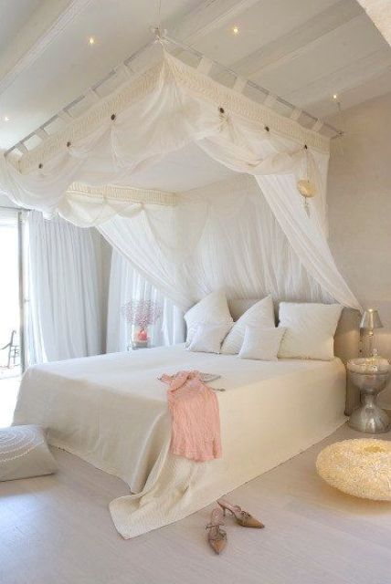 feminine bedroom, with a large canopy bed, the frame of which is attached to the ceiling