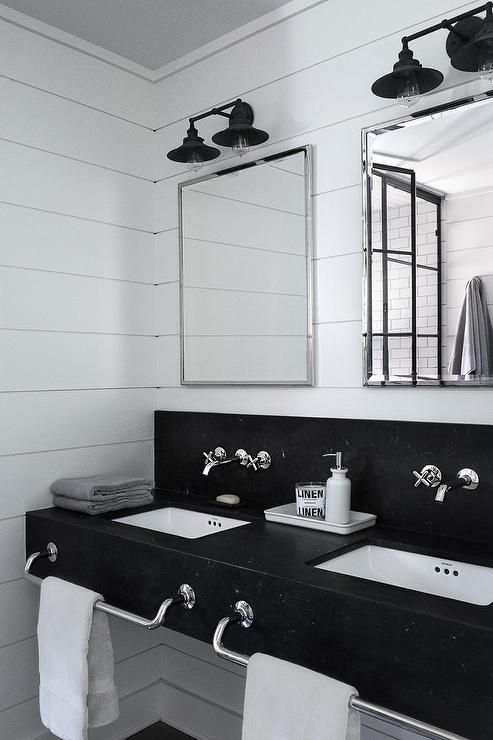 black and white industrial bathroom features a honed black marble floating dual vanity accented with built in polished nickel towel bars and square undermount sinks