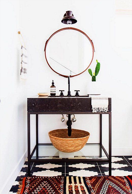stone vanity on metal legs with a glass shelf underneath