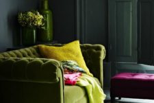 35 green plush sofa and bold yellow accents in a moody room