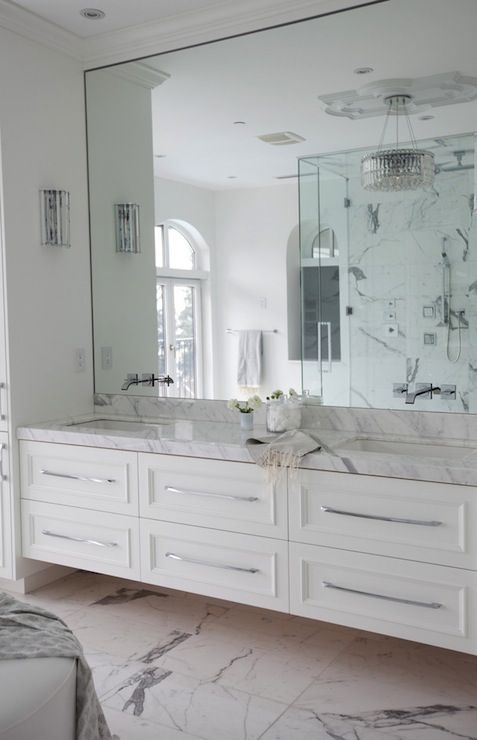White bathroom cabinetry with drawers and a marble top for a refined bathroom